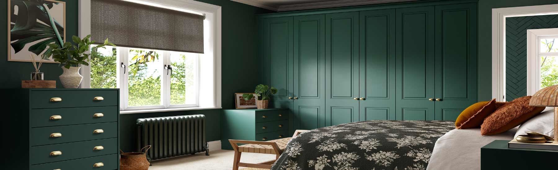 Cozy bedroom with dark green walls and furniture, a floral bedspread, woven rug, and a large window allowing natural light. Calm and inviting atmosphere.