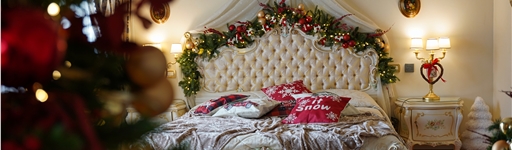 Bedroom with Christmas tree and garland across the headboard,